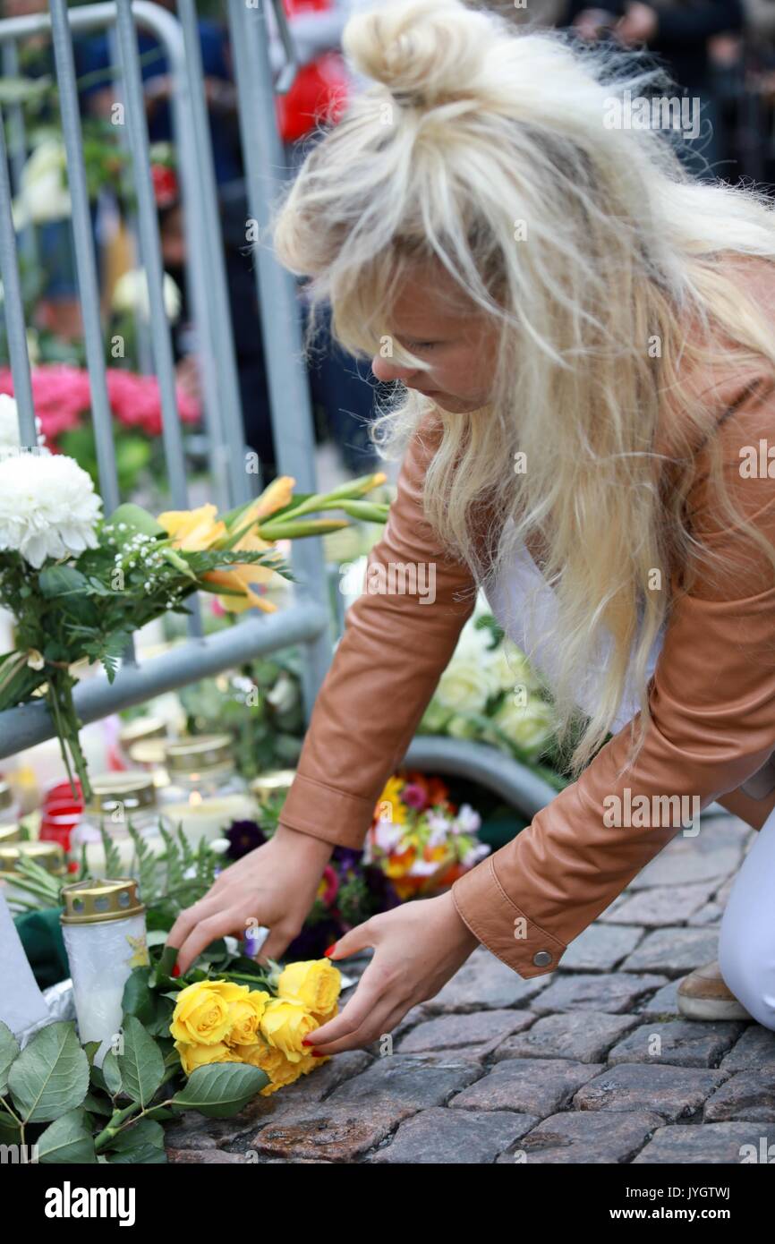 Turku, Finlandia. 19 Ago, 2017. Una donna mette un mazzo di fiori per commemorare le vittime del venerdì di stabbings lo a Turku Piazza del Mercato, Finlandia del 19 agosto, 2017. Un altro quattro marocchini sono stati arrestati e un mandato è stato emesso per un quinto dopo un giovane uomo pugnalato persone presso le piazze nel sud-ovest della città finlandese di Turku, la polizia ha detto che il sabato. (Xinhua/Zhang Xuan) (zjl) Credito: Xinhua/Alamy Live News Foto Stock