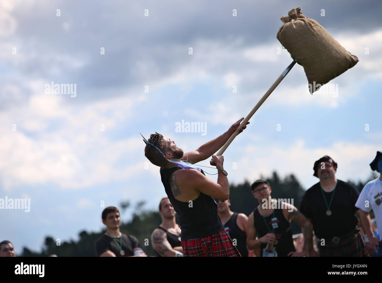 Horgenzell, Germania. 19 Ago, 2017. Un partecipante della tomaia Highlandgames sveva getta un sacco di fieno con una forcella di passo attraverso un ostacolo nella disciplina 'Sheaf Toss' in Horgenzell, Germania, 19 agosto 2017. 15 clan competere gli uni contro gli altri in varie discipline al Highlandgames. Foto: Karl-Josef Hildenbrand/dpa/Alamy Live News Foto Stock