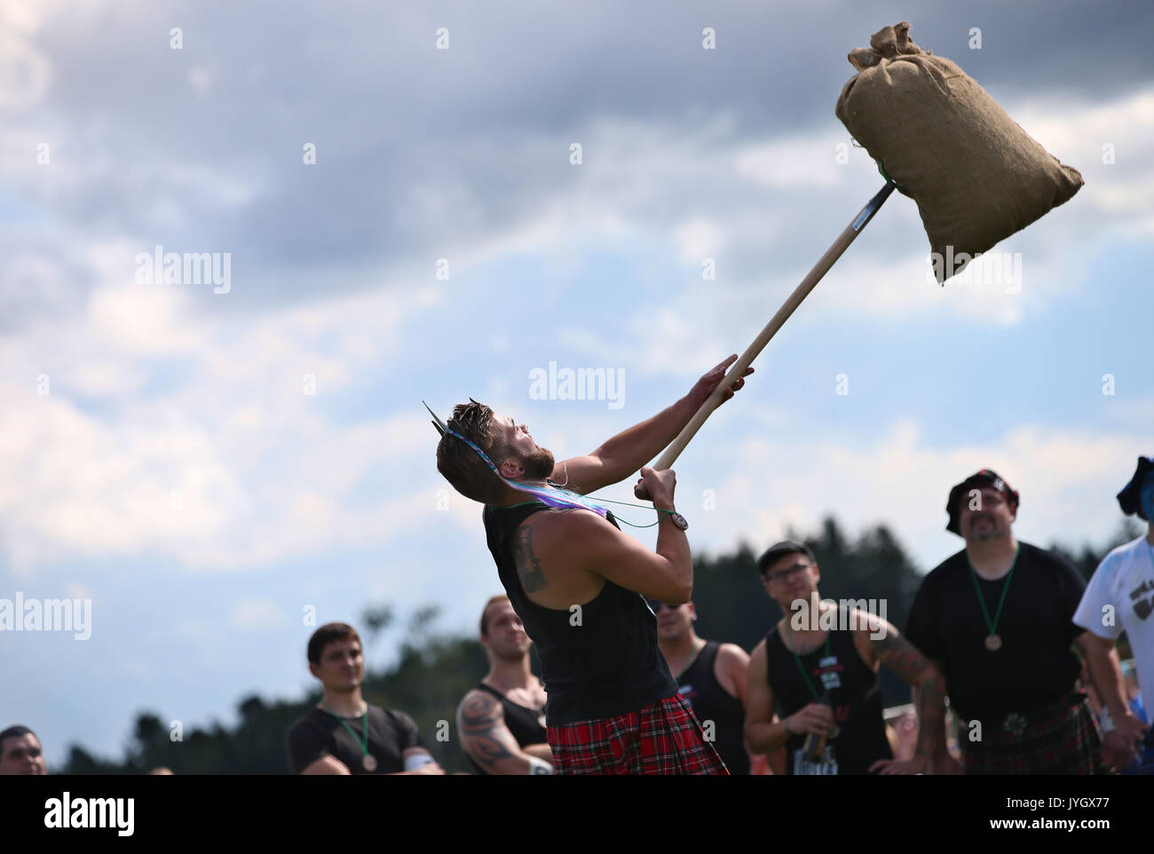 Horgenzell, Germania. 19 Ago, 2017. Un partecipante della tomaia Highlandgames sveva getta un sacco di fieno con una forcella di passo attraverso un ostacolo nella disciplina 'Sheaf Toss' in Horgenzell, Germania, 19 agosto 2017. 15 clan competere gli uni contro gli altri in varie discipline al Highlandgames. Foto: Karl-Josef Hildenbrand/dpa/Alamy Live News Foto Stock