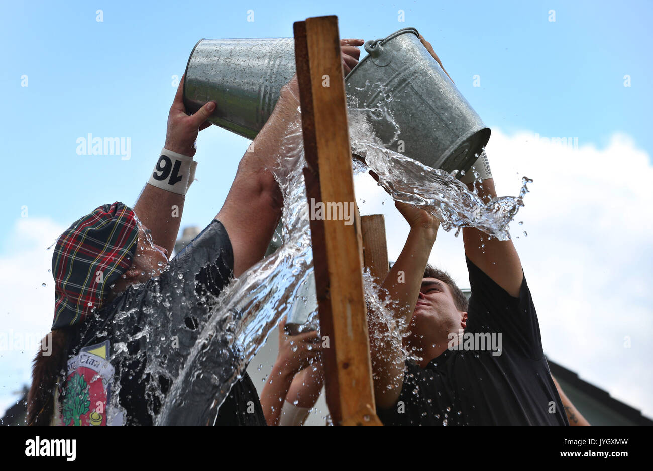 Horgenzell, Germania. 19 Ago, 2017. dpatop - i partecipanti della tomaia Highlandgames sveva di riempire di acqua in un secchio attraverso una barriera nella disciplina "ost-Schöpfa ' in Horgenzell, Germania, 19 agosto 2017. 15 clan competere gli uni contro gli altri in varie discipline al Highlandgames. Foto: Karl-Josef Hildenbrand/dpa/Alamy Live News Foto Stock