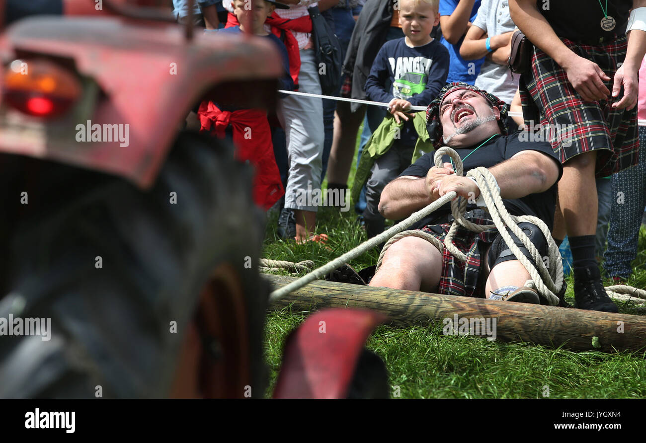 Horgenzell, Germania. 19 Ago, 2017. dpatop - un partecipante della tomaia Highlandgames sveva tira un trattore con una corda attraverso un prato nella disciplina "Bulldog-Schleppa' in Horgenzell, Germania, 19 agosto 2017. 15 clan competere gli uni contro gli altri in varie discipline al Highlandgames. Foto: Karl-Josef Hildenbrand/dpa/Alamy Live News Foto Stock
