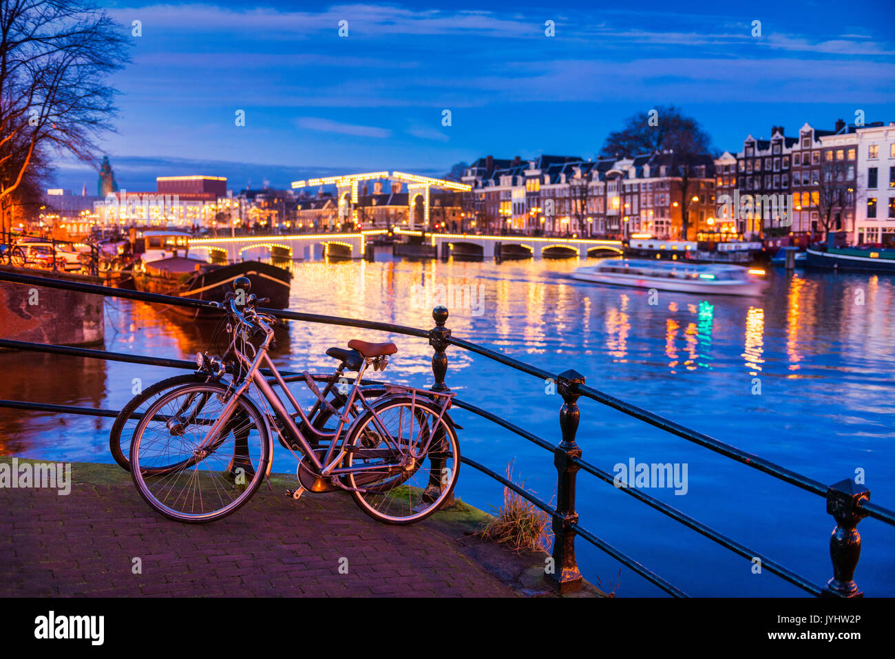 Skinny e il ponte sul fiume Amstel di Amsterdam Paesi Bassi al crepuscolo Foto Stock