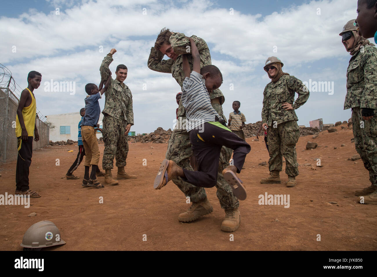 Stati Uniti Navy Seabees Petty Officer di terza classe Cayla George e marinaio Jesse Martinez assegnato a Combined Joint Task Force-Horn dell Africa a giocare con i bambini locali su un sito in costruzione nella regione di Arta, Gibuti, dove essi sono la costruzione di un centro medico, e il agosto 17, 2017. Il progetto è stato avviato da Naval Mobile Battaglione di costruzione uno (NMCB 1) e viene scaricata dal NMCB 133 che continuerà a lavorare sul progetto con piani di completamento nel 2018. (U.S. Air National Guard foto di Tech. Sgt. Joe Harwood) Foto Stock