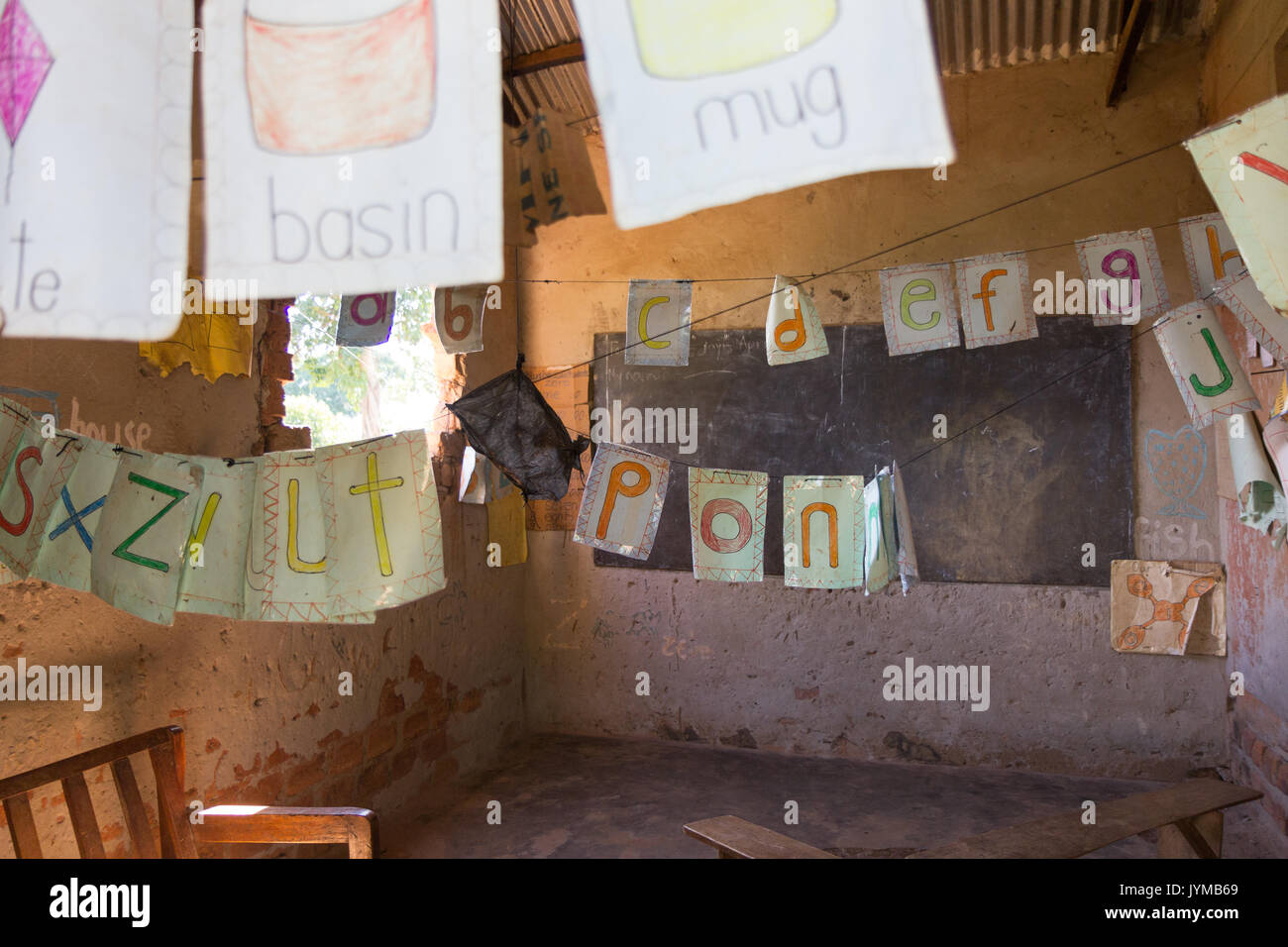 Lubanyi, Buikwe, Uganda. Il 28 aprile 2017. Una piccola aula in un primario rurale (elementari) scuola con una lavagna, pochi banchi e carte colorate Foto Stock
