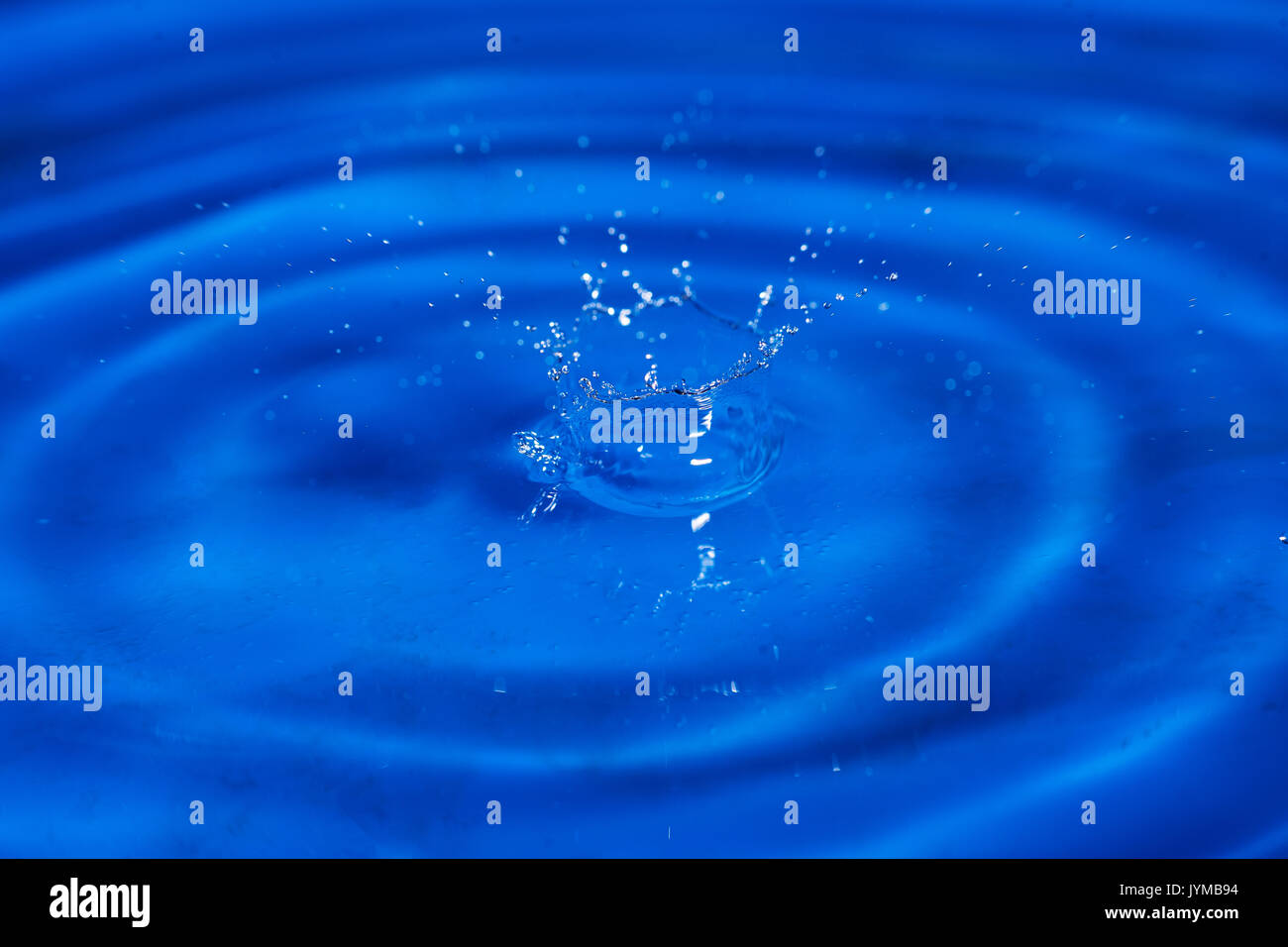 Macro shot della goccia d'acqua splash e tonificante blu Foto Stock
