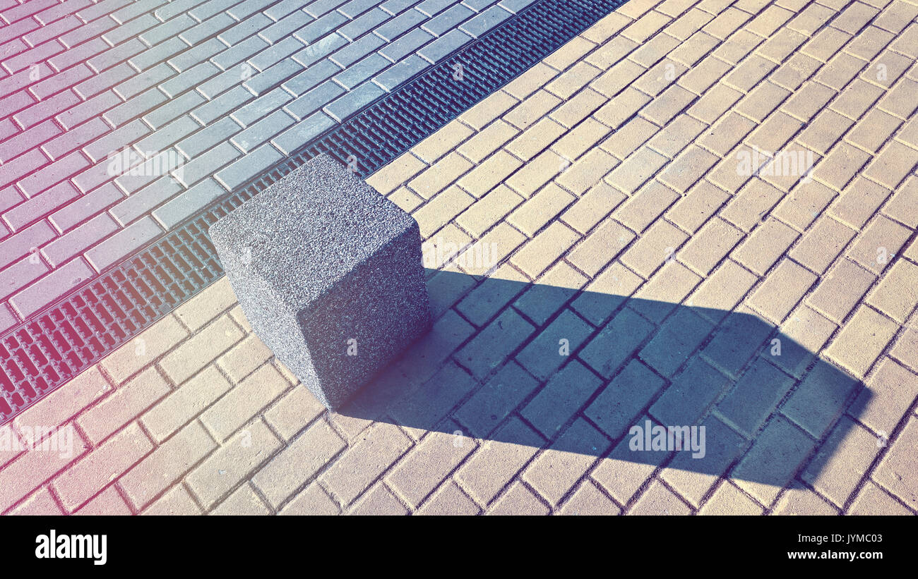 Vintage foto dai toni di un blocco in calcestruzzo sul marciapiede, abstract background urbano. Foto Stock