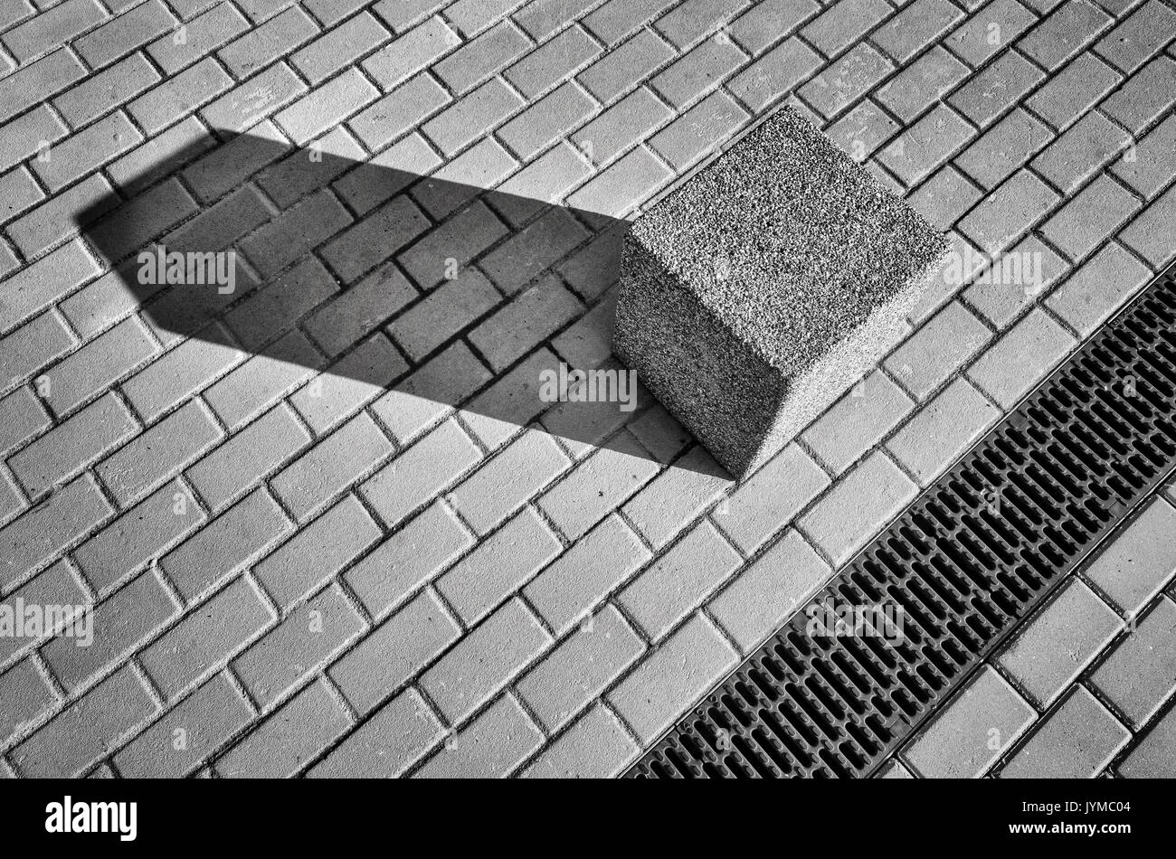 Immagine in bianco e nero di una strada e blocchi di cemento sulla pavimentazione, abstract background urbano. Foto Stock
