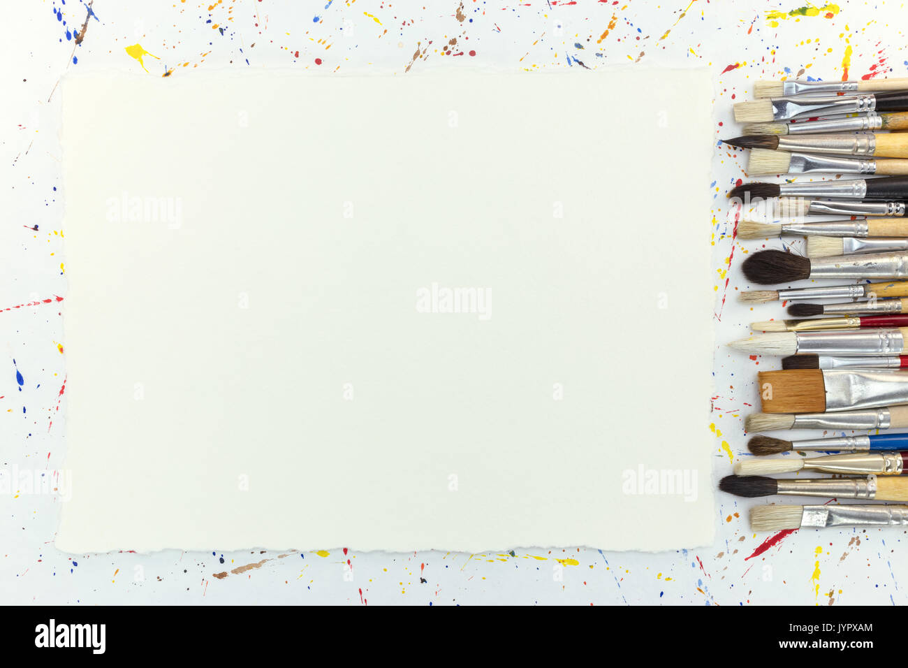 Vari set di pennelli e fustellato foglio di carta bianco su sfondo con acquarello blobs Foto Stock