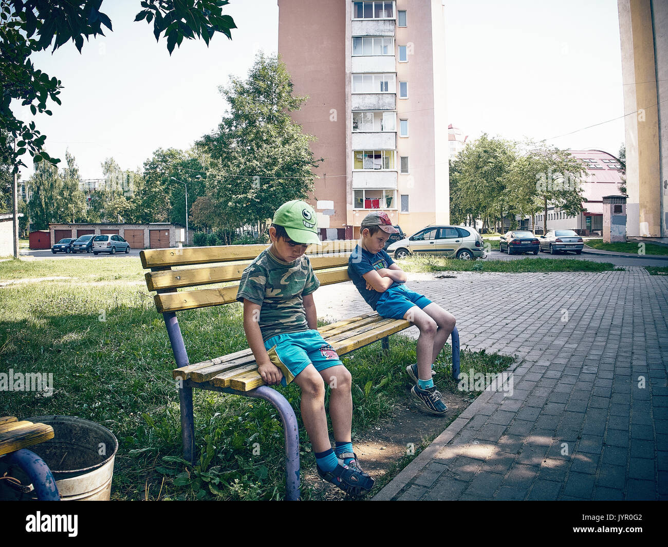 Due ragazzi di sedersi su lati opposti del banco. Essi avevano una caduta e non si vuole parlare di ogni altro. Foto Stock