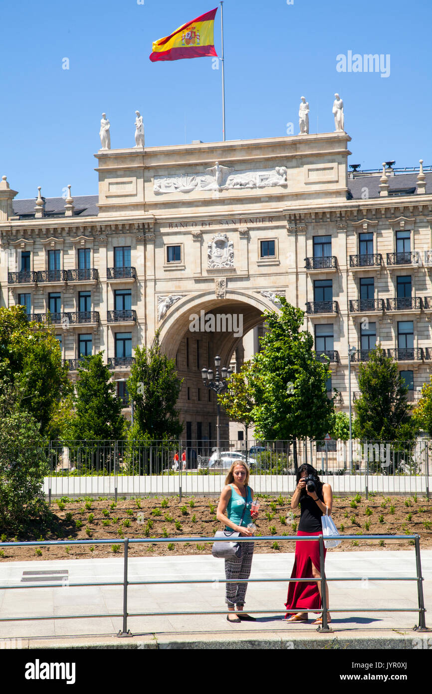 Due donne turisti scattano fotografie di fronte alla sede centrale della banca di Santander/ Banco Santander Santander in Spagna Foto Stock