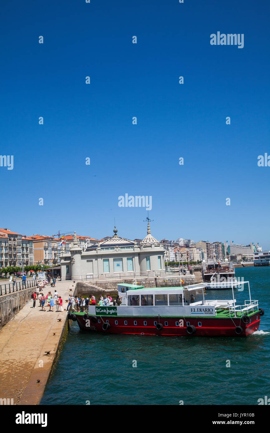 Villeggianti e turisti a salire su un piccolo viaggio di piacere barca al porto di Santander in Spagna per un viaggio intorno alla baia Foto Stock