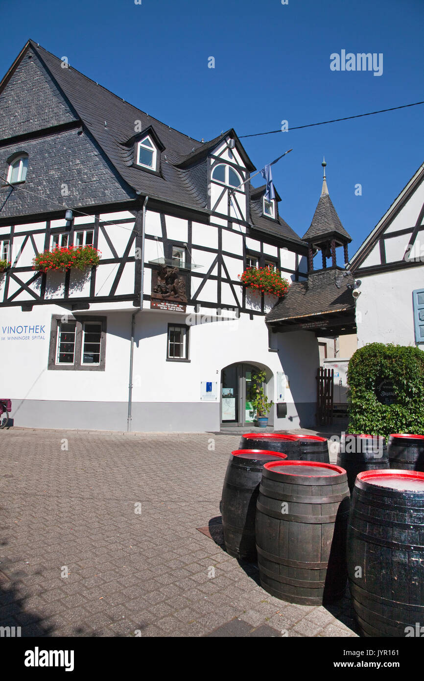 Fachwerkhaus und Weinfaesser am Weinhexbrunnen im Winningen Weinort, Untermosel, Landkreis Mayen-Koblenz Renania-Palatinato, Deutschland, Europa | semi- Foto Stock