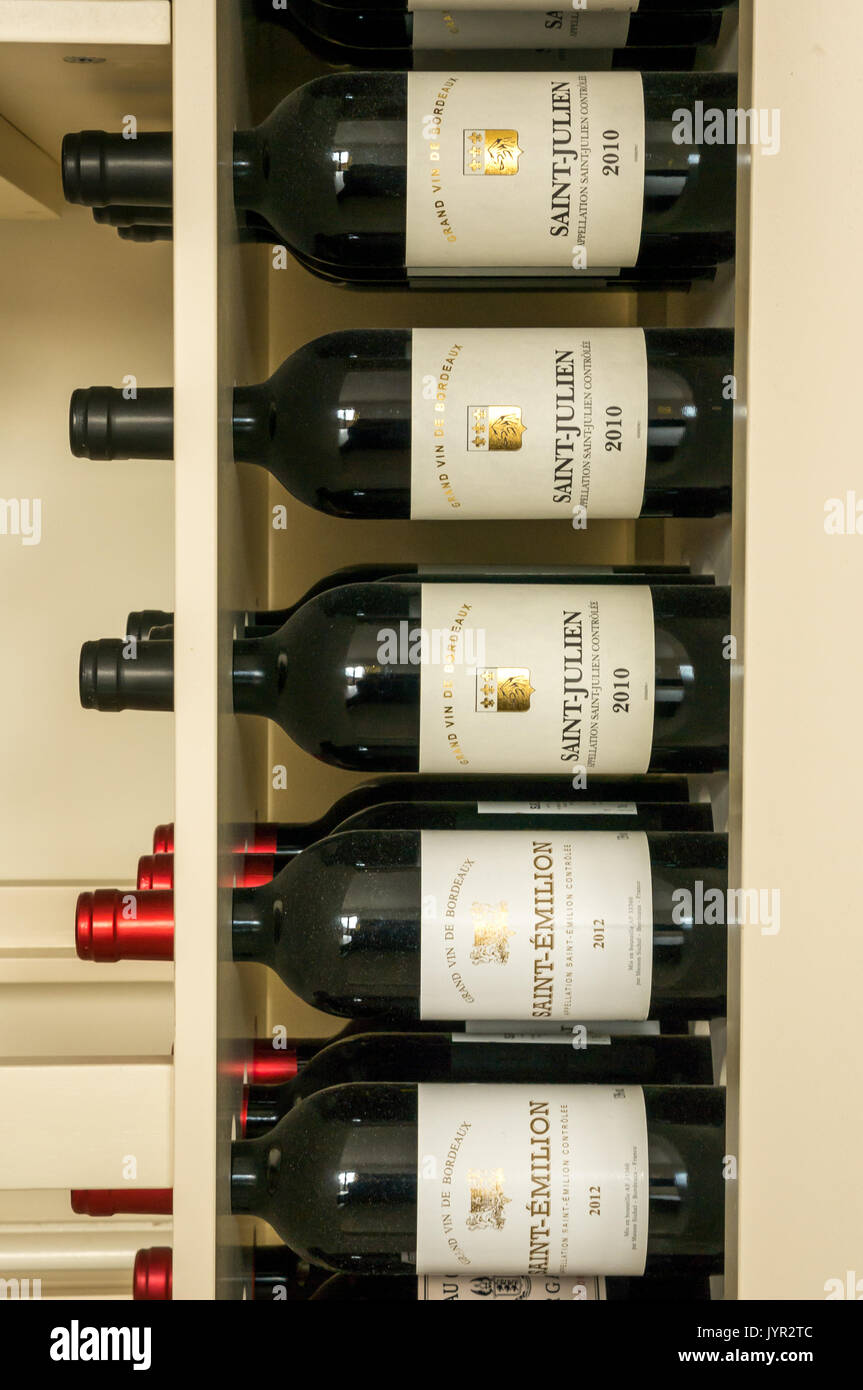 Bottiglie di vino rosso in un rack dalla regione di Bordeaux in Francia, tra cui Saint Julien e Saint Emilion Foto Stock