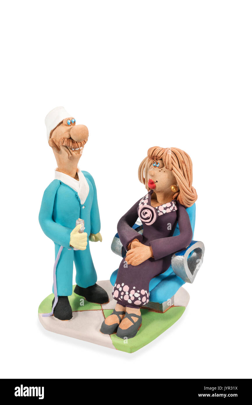 Figurine di argilla di un dentista permanente e il paziente seduto in una sedia isolato su uno sfondo bianco Foto Stock