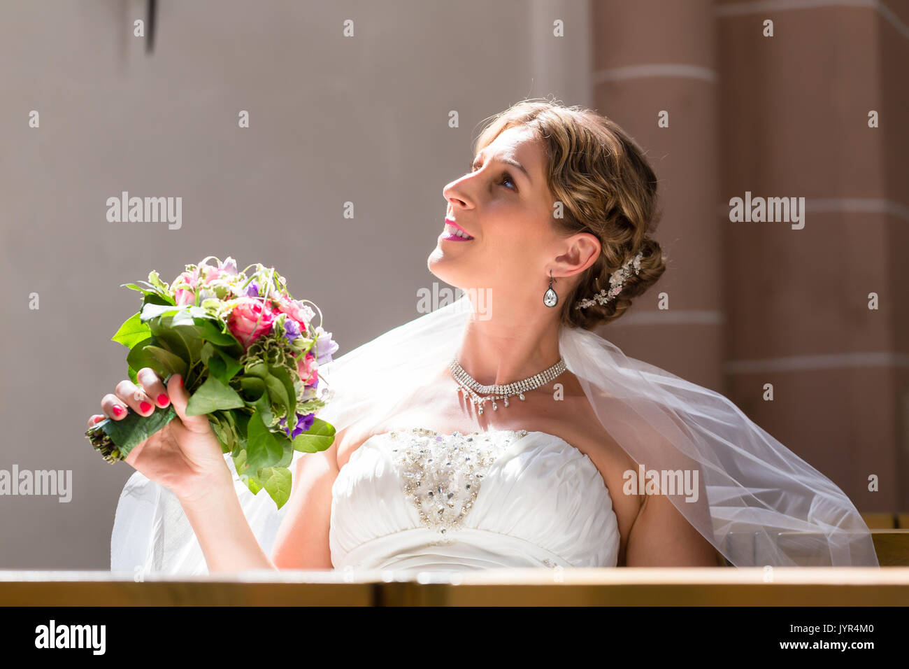 Sposa ad un matrimonio in chiesa con il mazzo di fiori Foto Stock