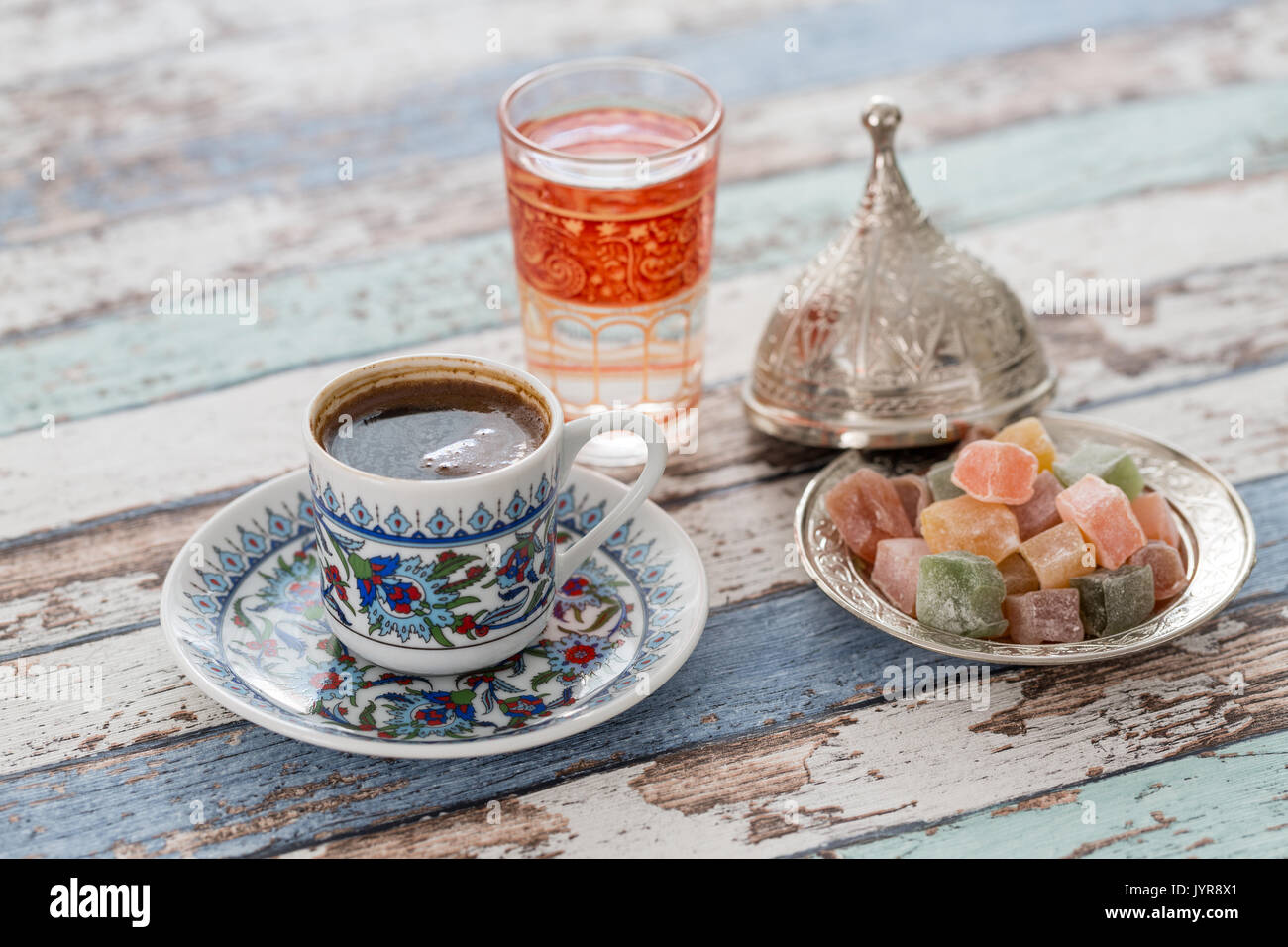 Il caffè turco è servita in un tradizionale bagno turco tazza di caffè in  un vassoio di rame Un bicchiere di acqua con un petalo di rosa e le delizie  turche sul