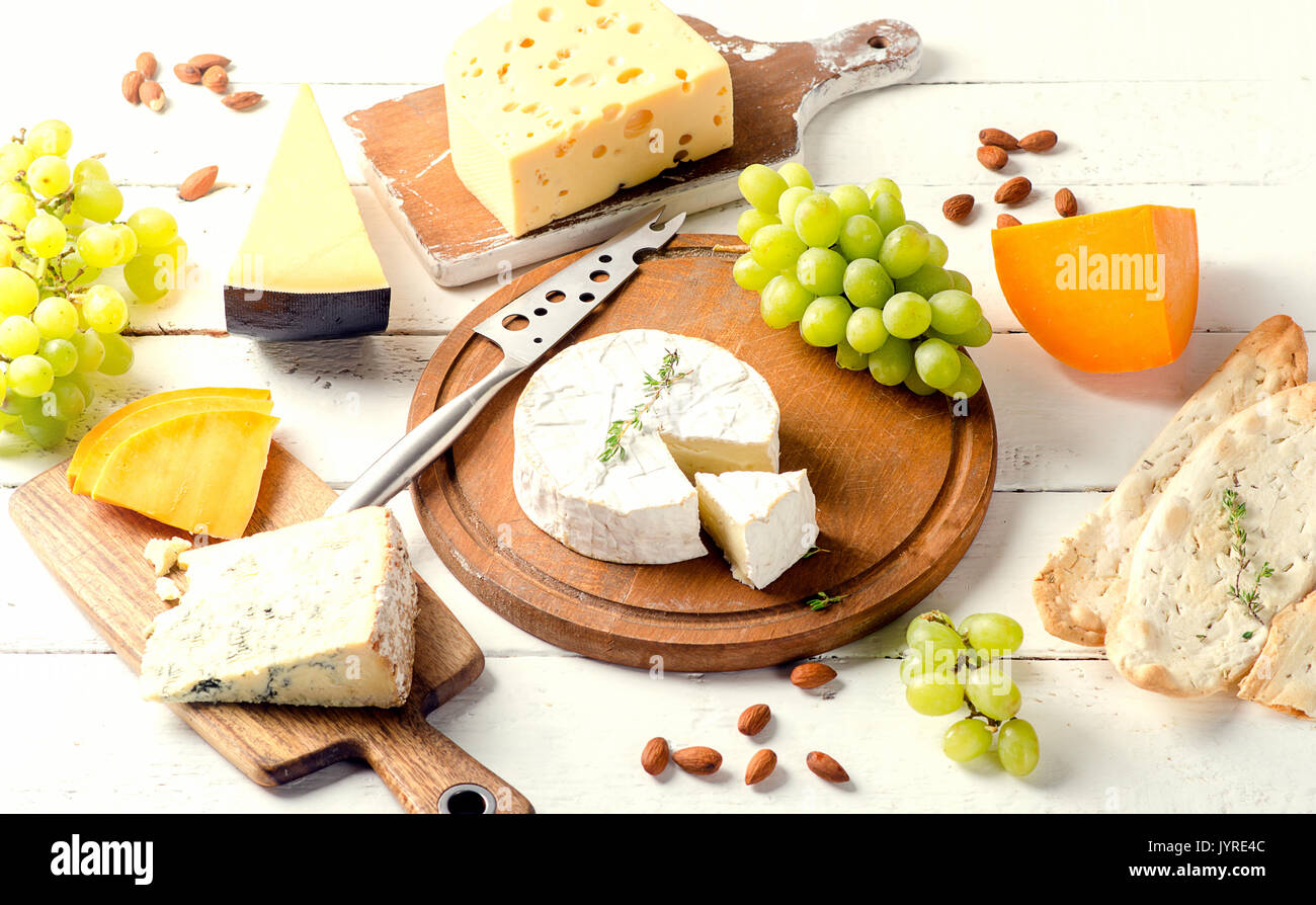 Diversi tipi di formaggi su bianco tavola di legno. Foto Stock