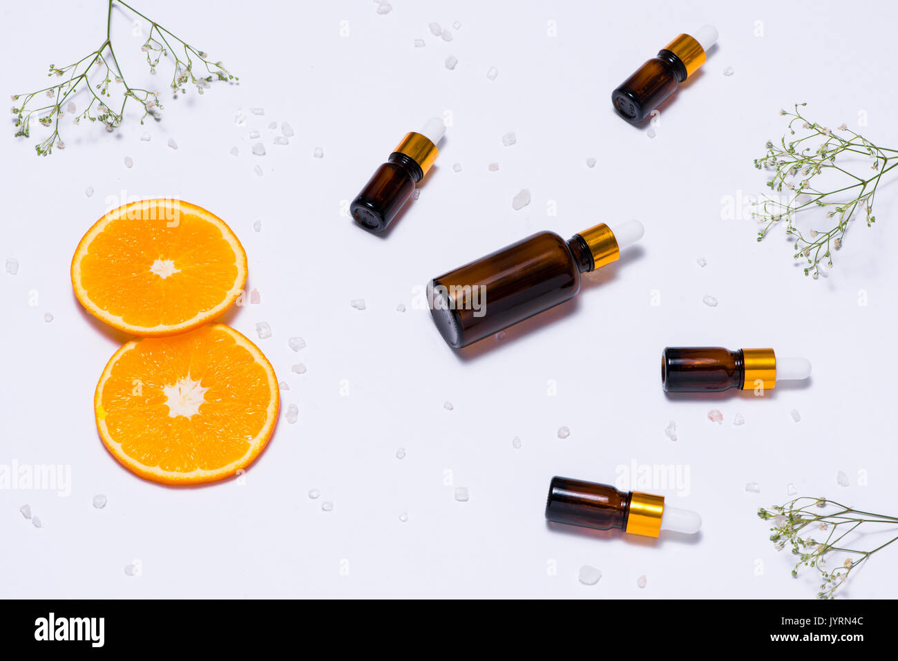 Il Branding mock-up. Olio essenziale naturale, bottiglia di cosmetici contenitori con fettine di arancia. Foto Stock