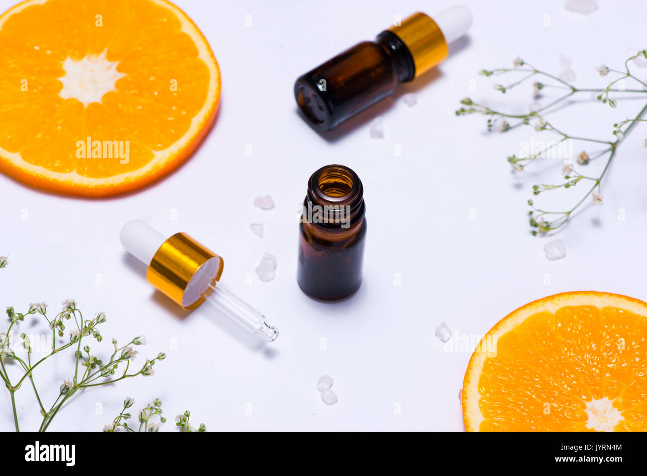 Il Branding mock-up. Olio essenziale naturale, bottiglia di cosmetici contenitori con fettine di arancia. Foto Stock