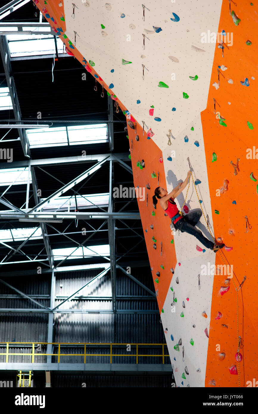 Giovane donna arrampicata indoor parete. l'Europa. Foto Stock