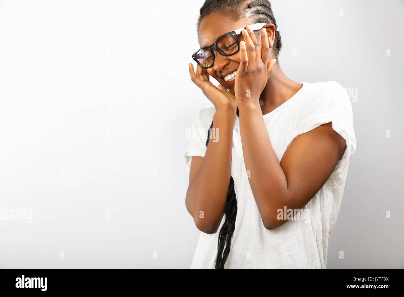 Felice e sorridente donna africana con gli occhiali in una camicia bianca Foto Stock Felice e sorridente donna africana con gli occhiali in una camicia bianca Foto Stock
