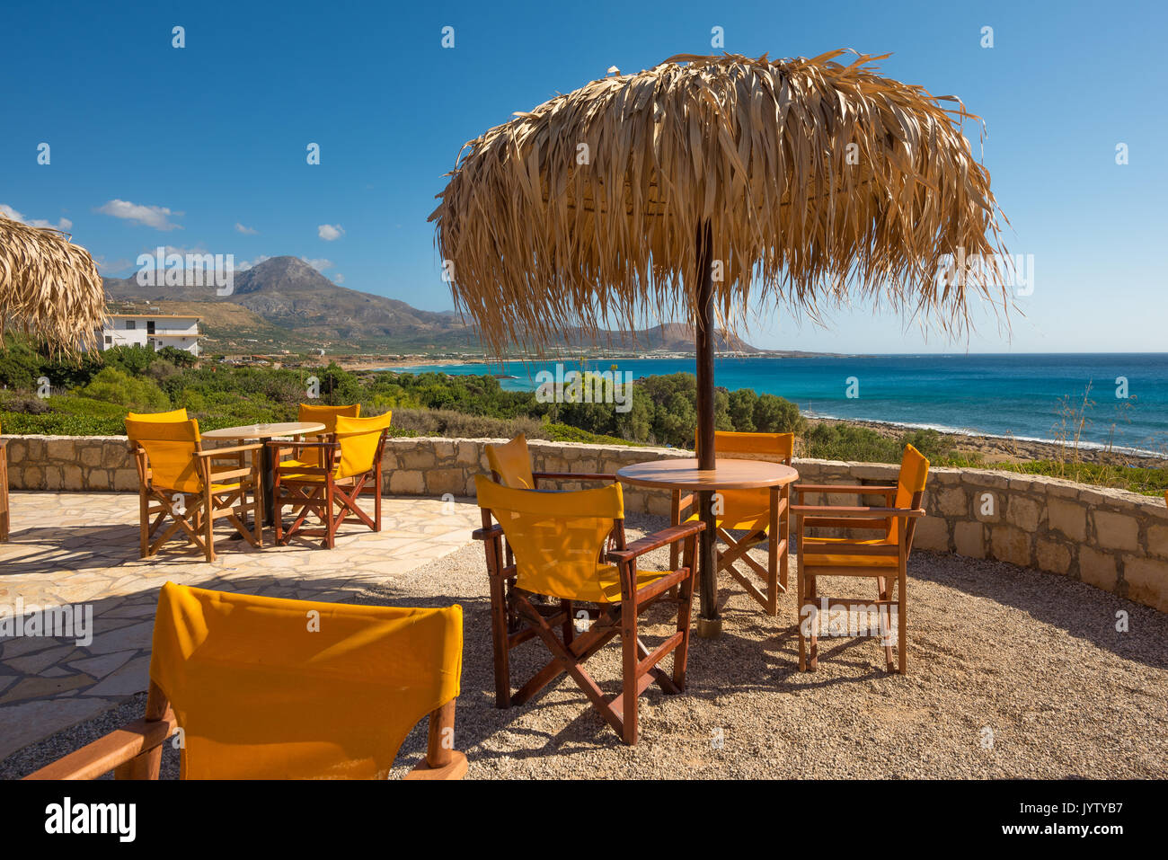Posti a sedere nel snack bar sotto l'ombrellone che si affaccia sul mare durante la calda estate nel pomeriggio Foto Stock