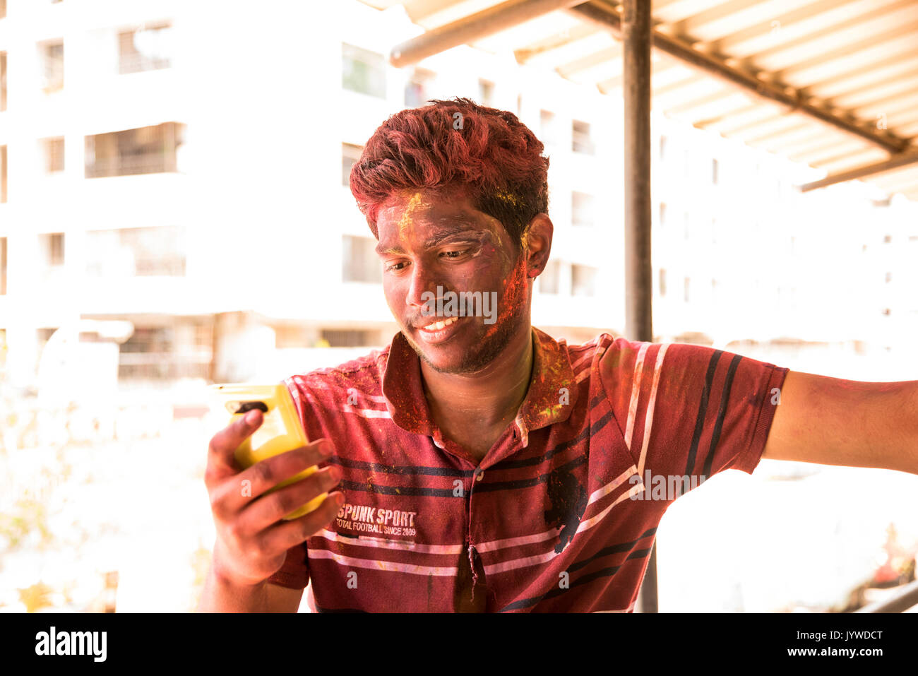 MUMBAI, Maharashtra, India - 16 Marzo: un ragazzo alla ricerca di mobili e sorridente dopo la celebrazione il festival indiano di colori, Holi il 16 marzo 2016 in Foto Stock