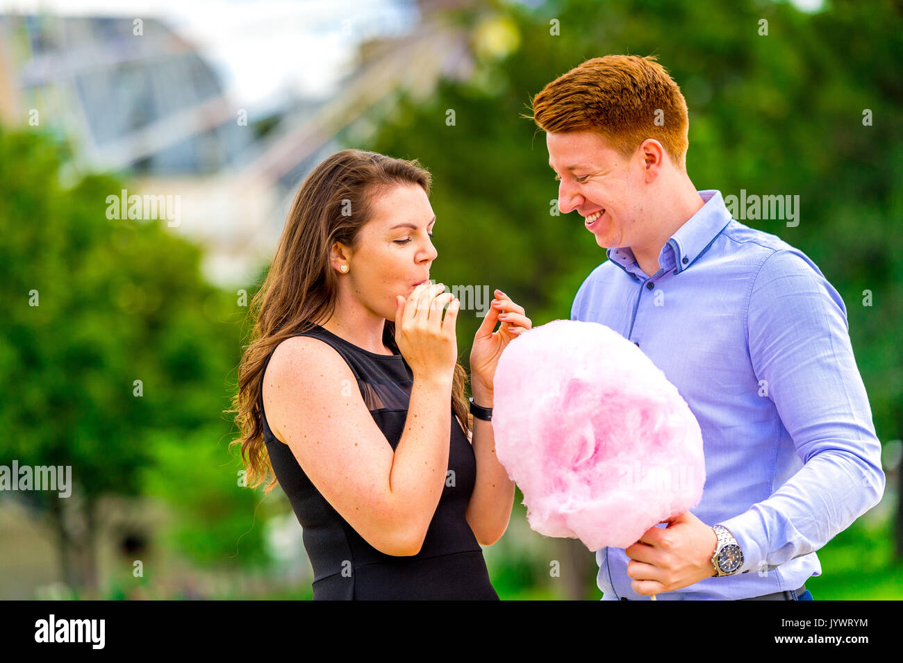 Giovane coppia innamorata ride mentre si mangia fata floss fuori dalla Fete des Tuileries a Parigi Foto Stock