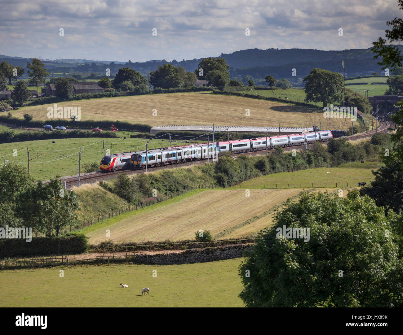 Primo Transpennine express classe 350 e una Vergine treni pendolino pass a Rowell (tra Carnforth & Oxenholme) sulla linea principale della costa occidentale Foto Stock