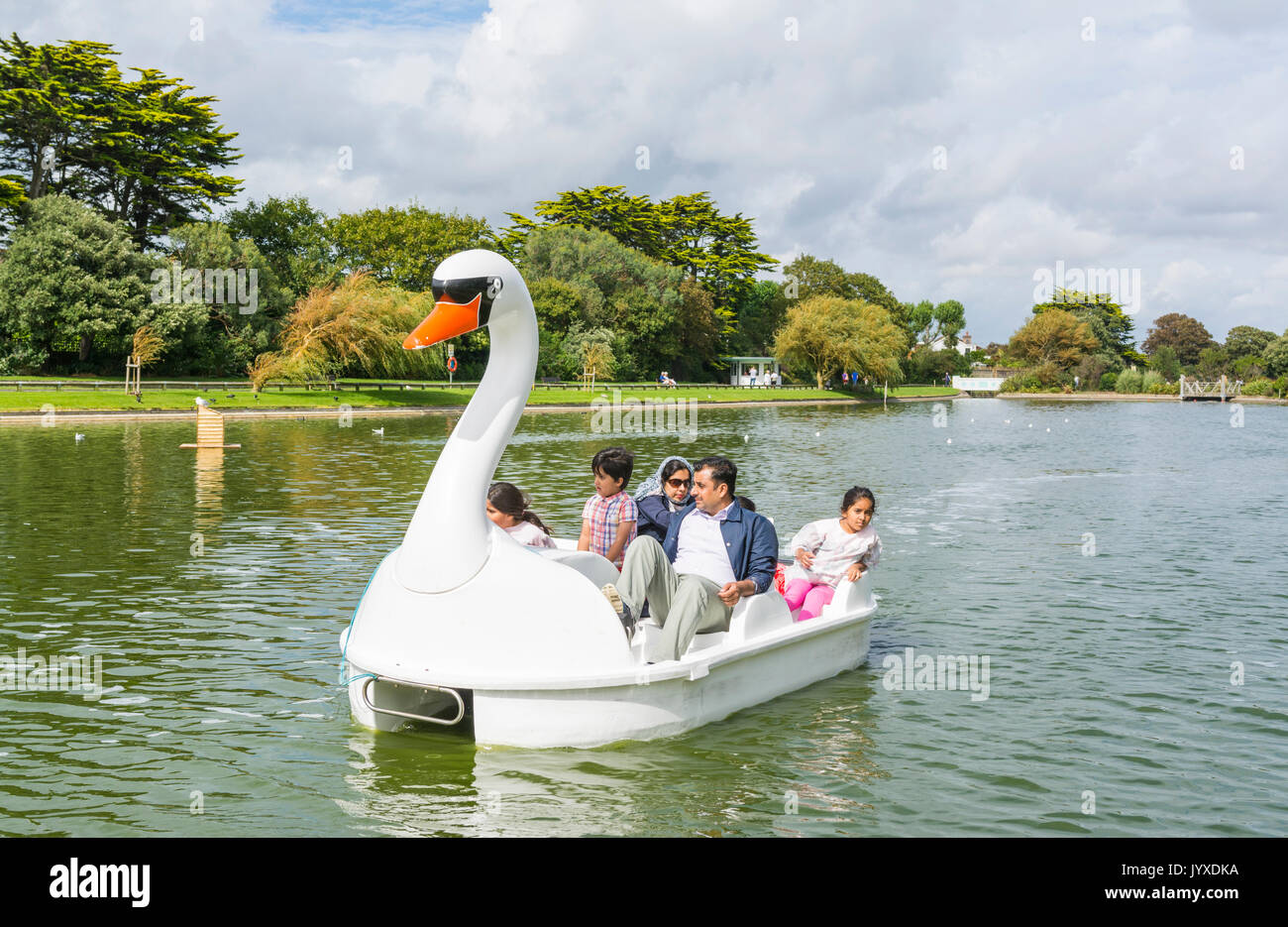 Parco Mewsbrook, Littlehampton, West Sussex, in Inghilterra, Regno Unito. Domenica 20 agosto 2017. Regno Unito Meteo. Una famiglia amano cavalcare su un pedelo sul lago in barca al Parco Mewsbrook in Littlehampton questo pomeriggio. Il tempo è nuvoloso ma abbastanza caldo e secco, vicino alla costa sud dell'Inghilterra. Credito: Geoff Smith/Alamy Live News Foto Stock