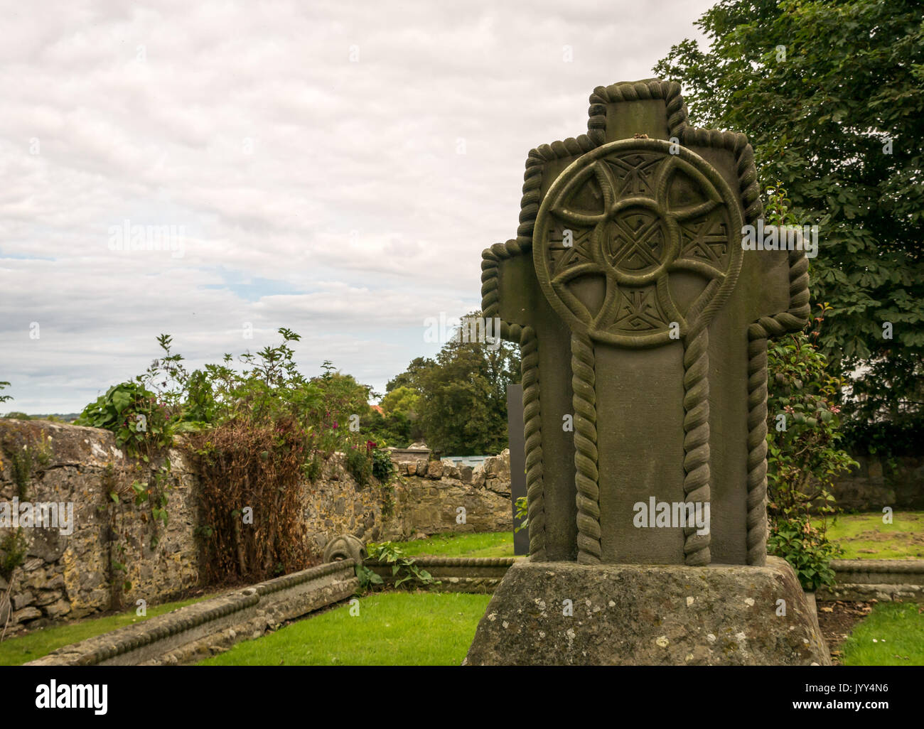 Close up ornati lapide scolpita per la famiglia Charteris, a Aberlady Chiesa Parrocchiale cimitero, East Lothian, Scozia, con il grigio cielo molto nuvoloso in estate Foto Stock