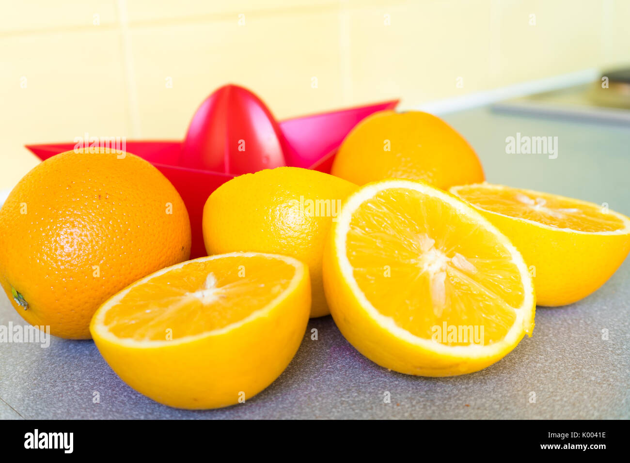 Dimezzato le arance e un rosso arancione in plastica centrifuga Foto Stock