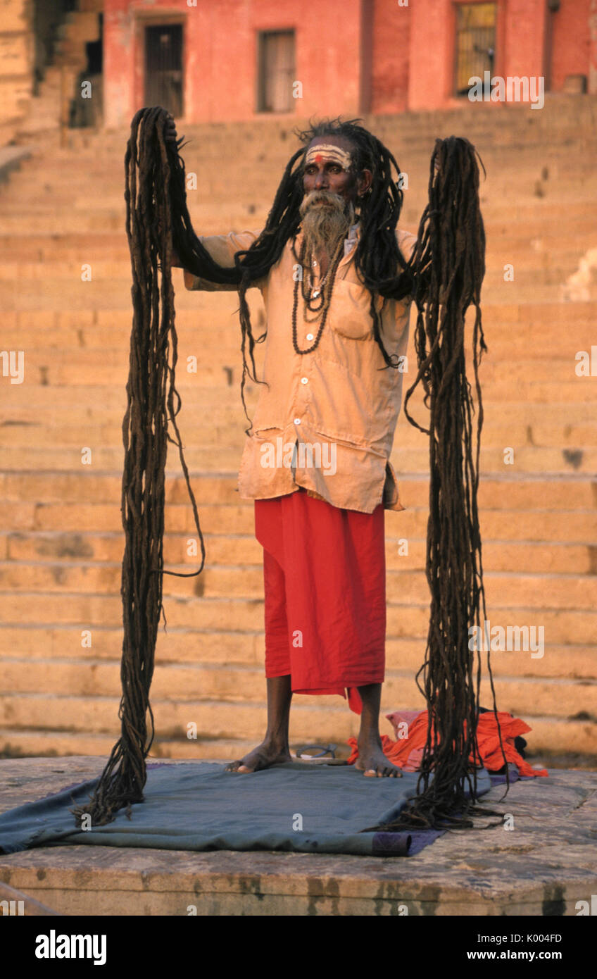 Ascetica con capelli non tagliato sui ghat lungo il fiume Gange, Varanasi (Benares, Banaras), India Foto Stock