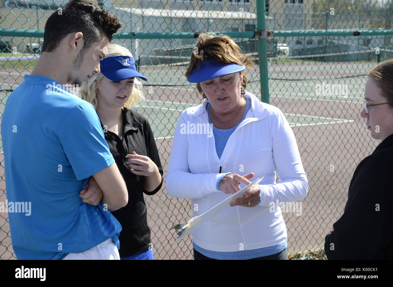 Coach parlando con diversi giocatori di tennis Foto Stock