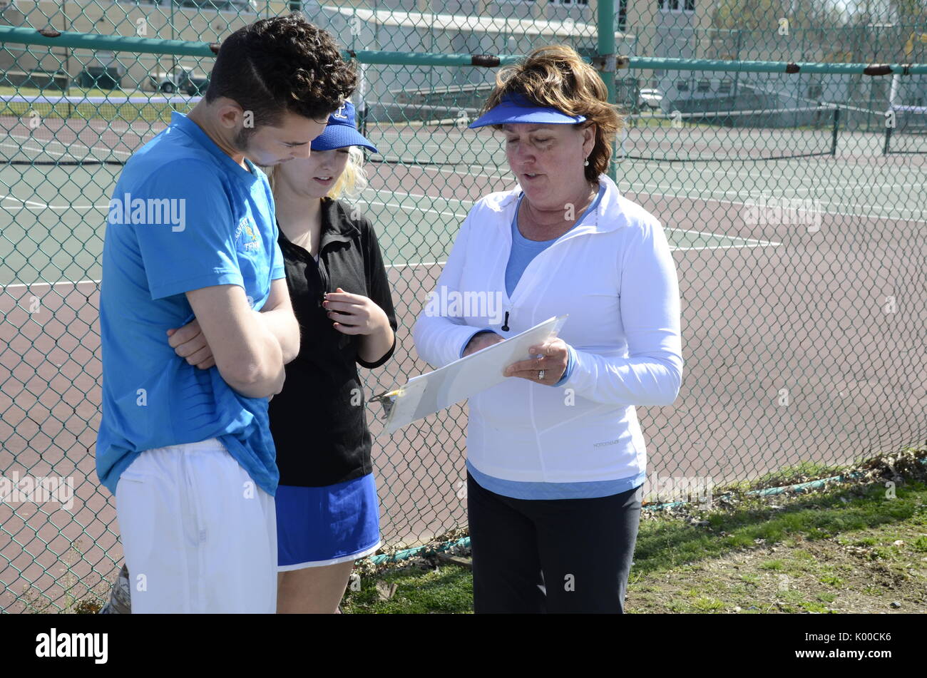 Coach parlando con diversi giocatori di tennis Foto Stock