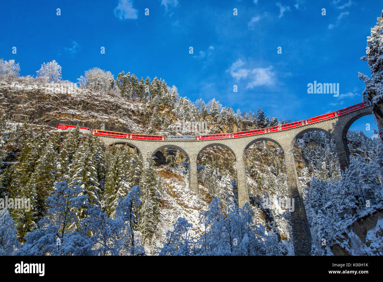 Bernina Express passa attraverso i boschi innevati Filisur Cantone dei Grigioni Svizzera Europa Foto Stock