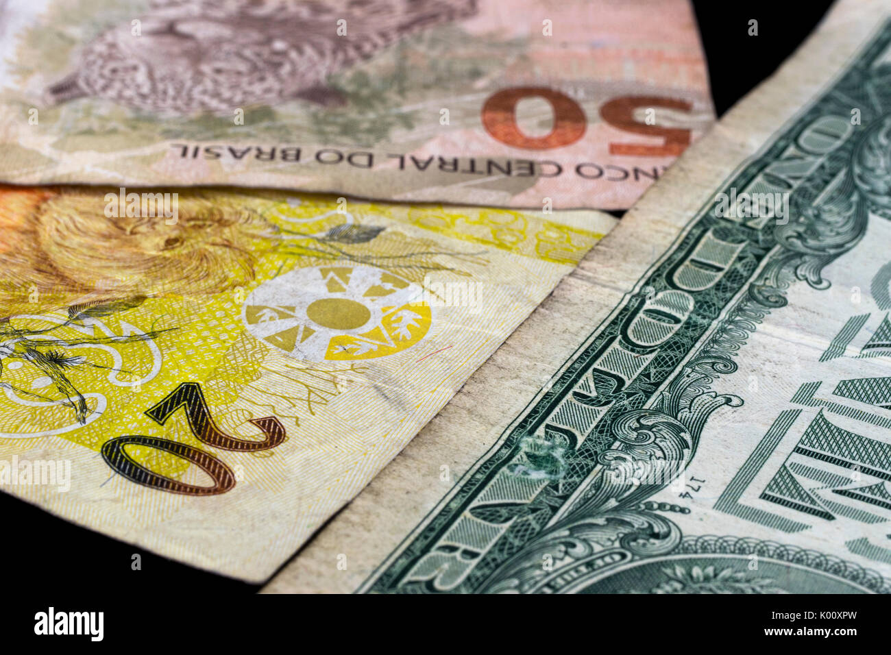 Due brasiliane denaro reale di banconote e un US dollar nota Foto Stock