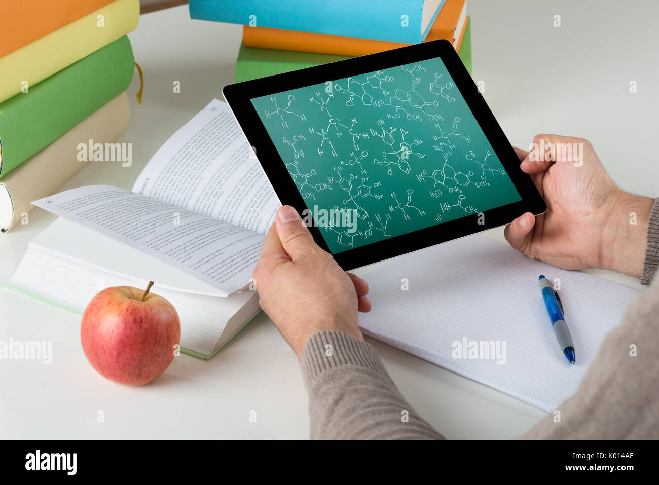 Angolo di alta vista di apprendimento dello studente formule chimiche sulla tavoletta digitale alla scrivania Foto Stock