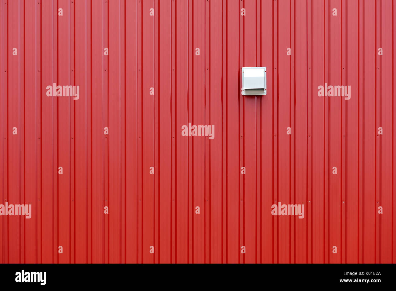 Rosso parete stagno con linee verticali e beige e lo sfiato di scarico Foto Stock