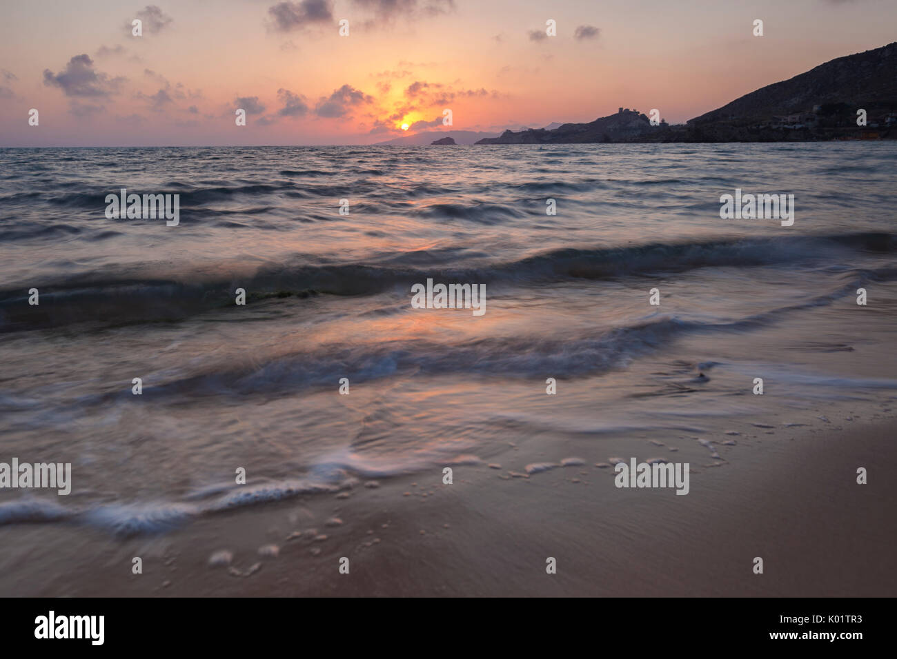 Le ultime luci del tramonto si riflettono sulle onde del mare e la spiaggia sabbiosa di Licata in provincia di Agrigento Sicilia Italia Europa Foto Stock