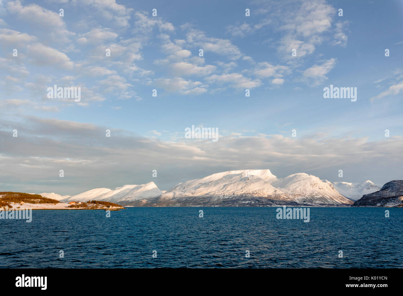 Cielo blu sulle cime innevate circondate dal mare frozen Olderdalen Kafjorden Alpi Lyngen Tromsø Norvegia Europa Foto Stock