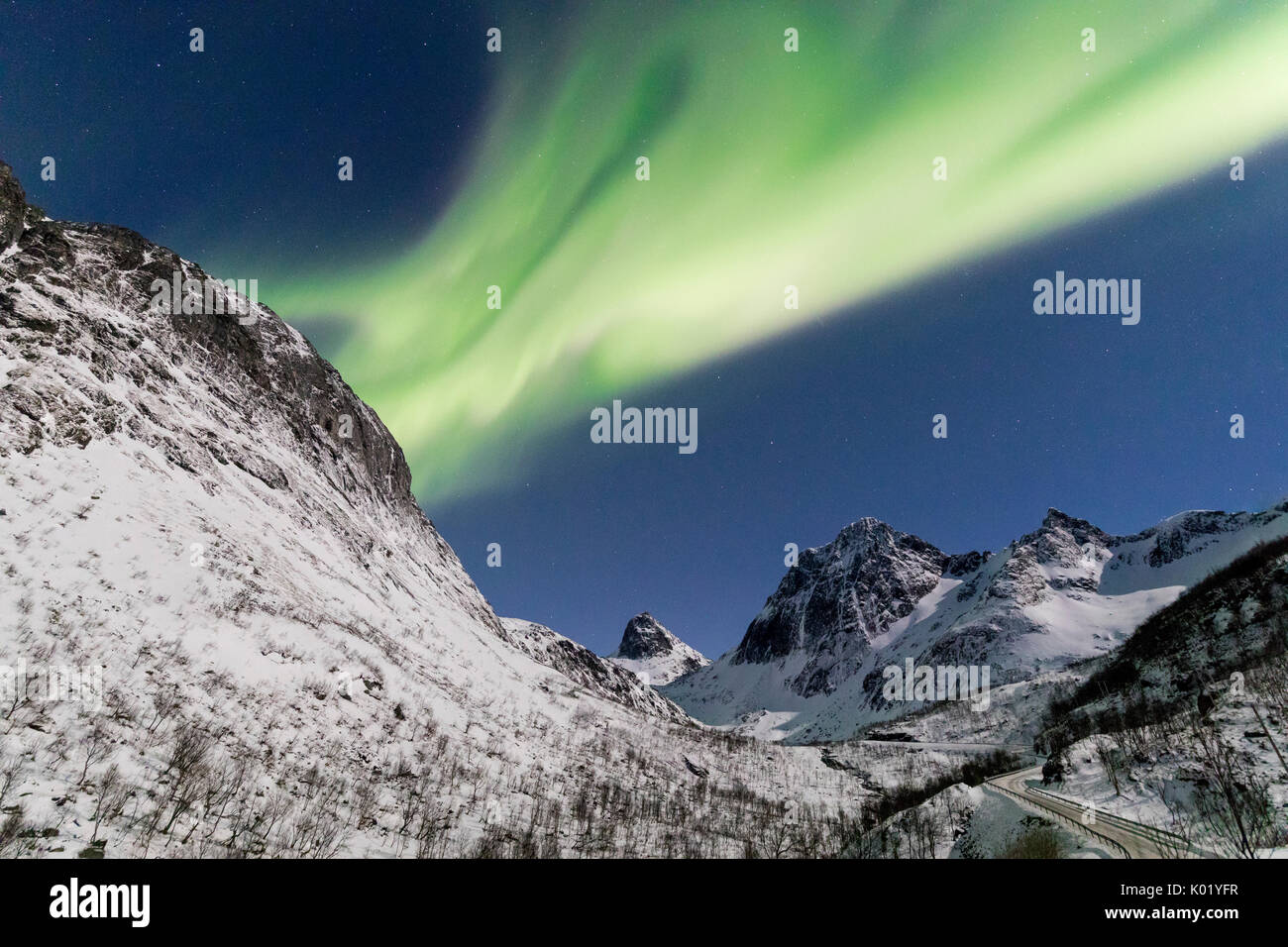 Luci del nord e stelle sulle cime innevate lungo la nazionale percorso turistico Bergsbotn Senja Tromsø Norvegia Europa Foto Stock
