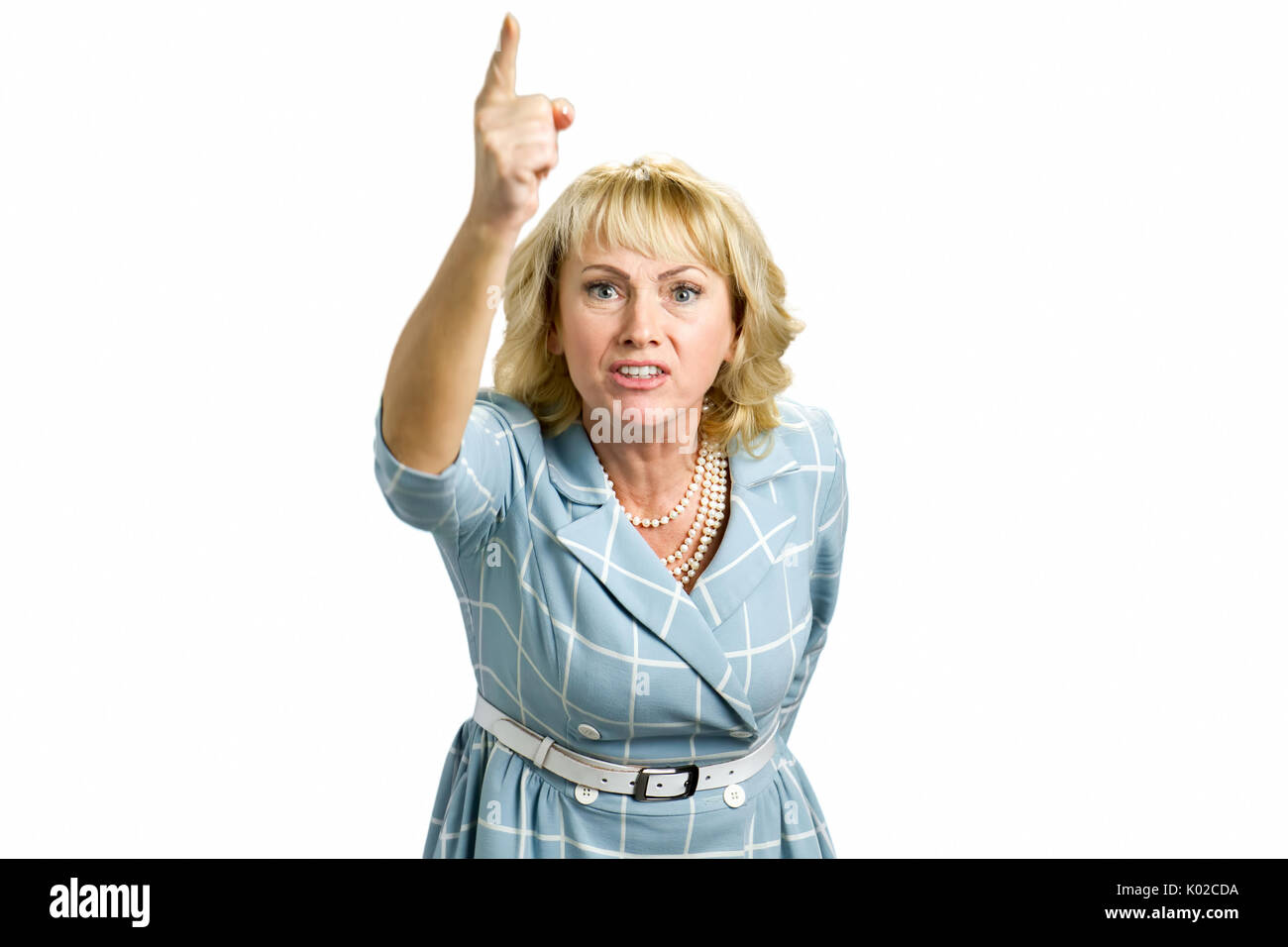 Donna Frustrarted mano sollevata verso l'alto. Infastiditi donna matura rivolto verso l'alto, sfondo bianco. Arrabbiato donna bionda scolding qualcuno e dispositivo di puntamento con la sua aletta Foto Stock