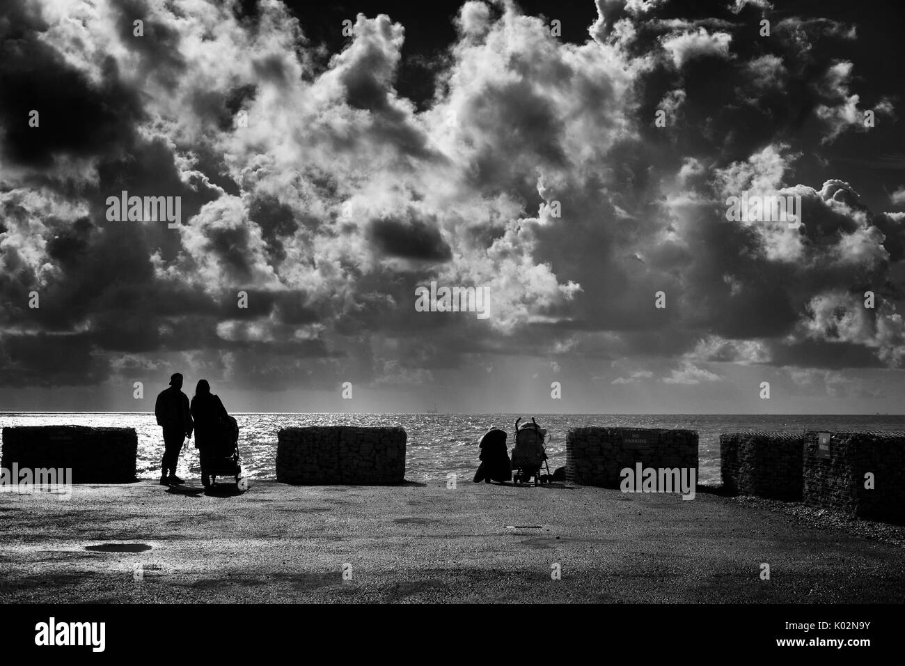 Le famiglie che guarda al mare orizzonte, Brighton Foto Stock