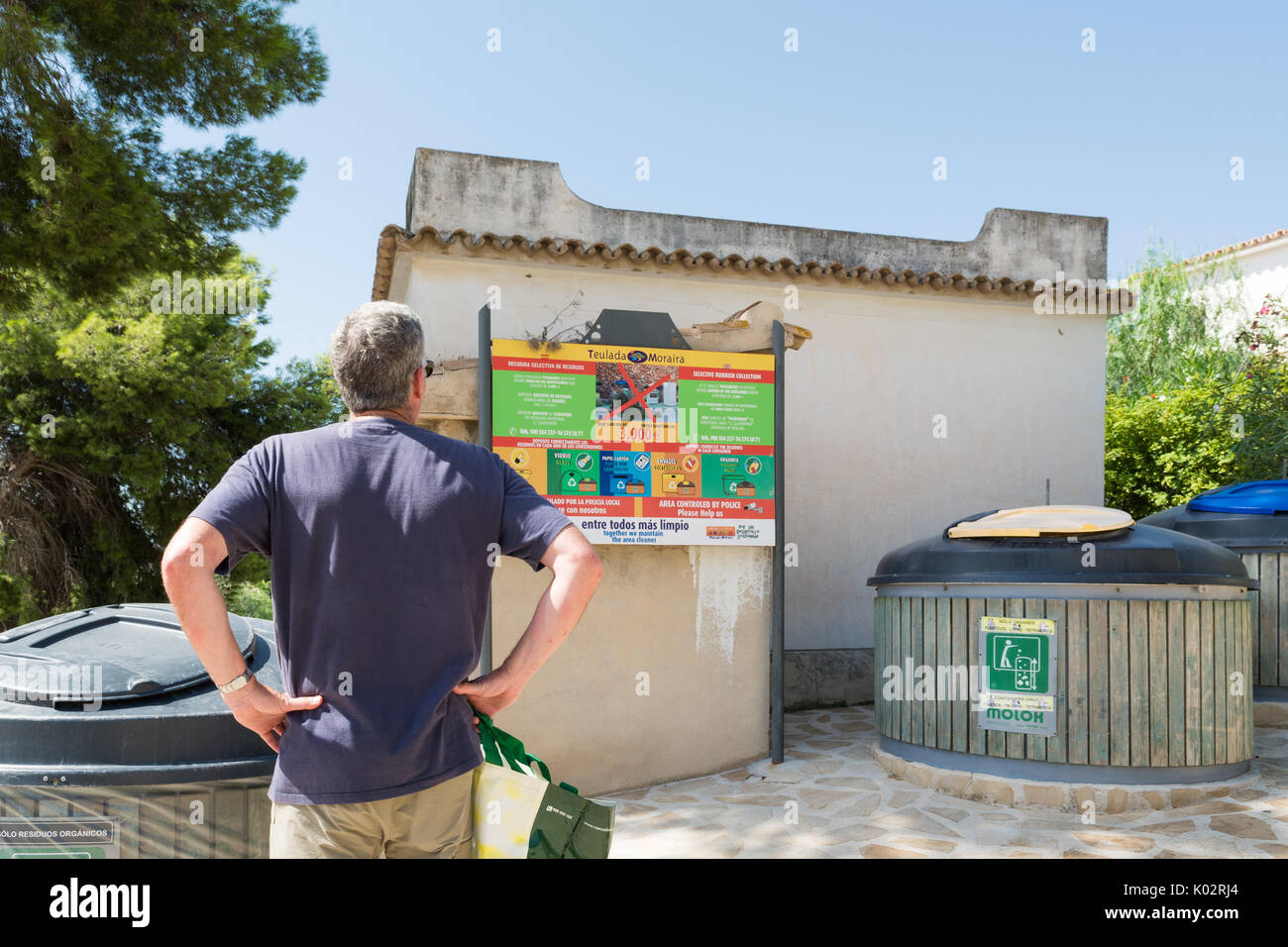 Il riciclaggio in vacanza - tourist guardando le strutture di riciclo vicino a spagnolo villa per vacanze Foto Stock