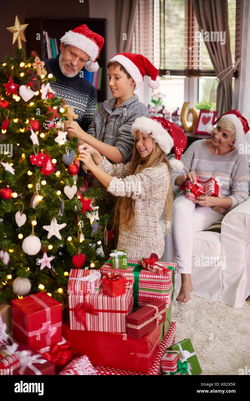 Tutta la famiglia vestire un albero di natale Foto Stock