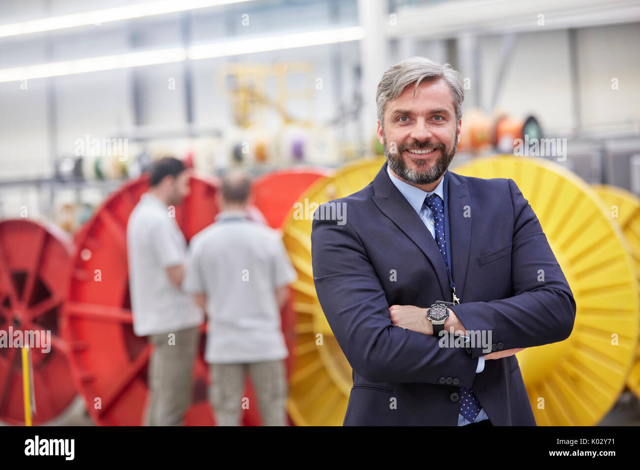 Ritratto sorridente, imprenditore fiducioso in fibre ottiche factory Foto Stock