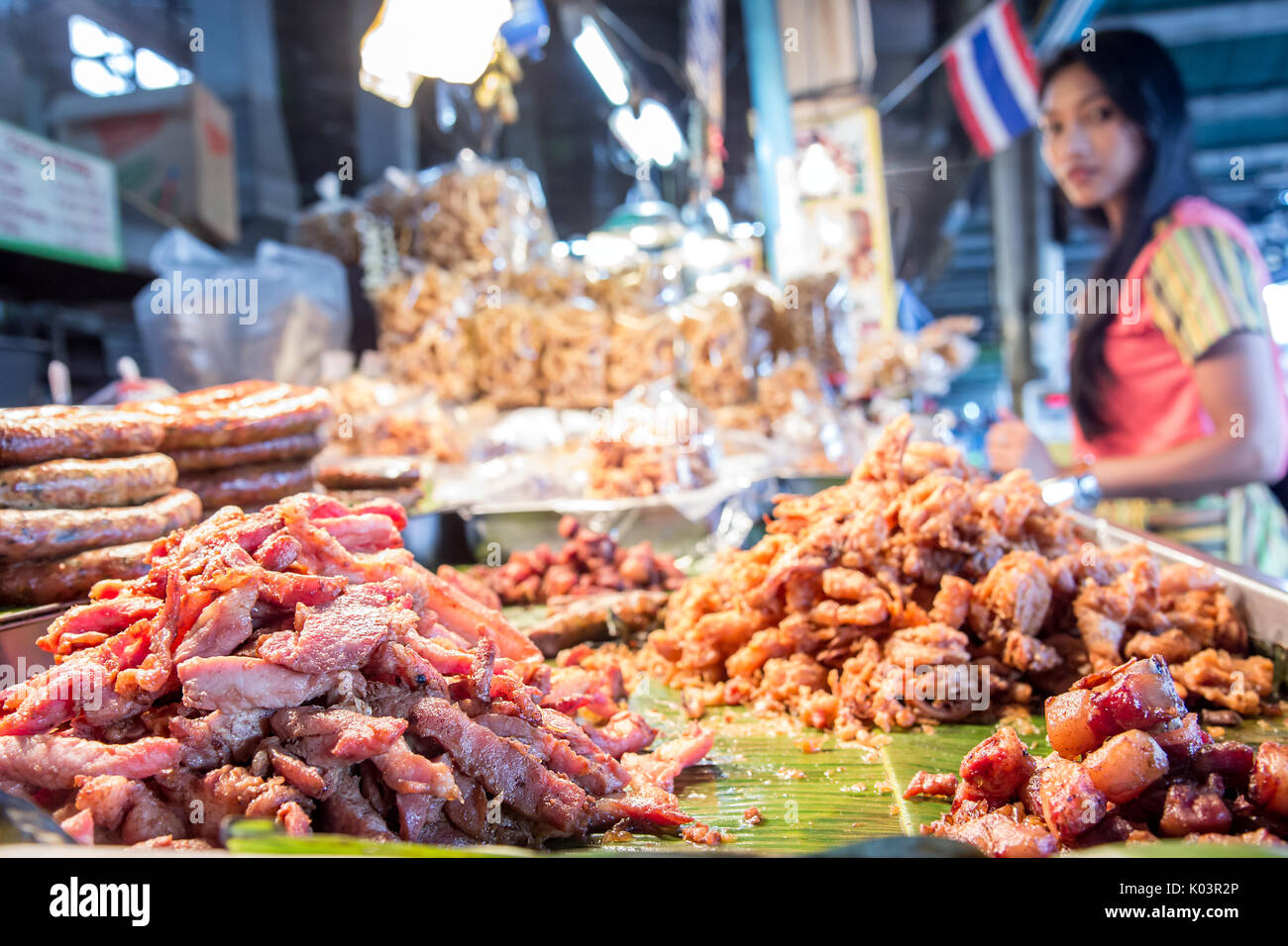 Carne di maiale alla griglia su foglia verde closeup, street market, Chiang Mai, Thailandia. Offrire carne arrosto su di una tavola di chiosco sulla strada, in Asia. Foto Stock