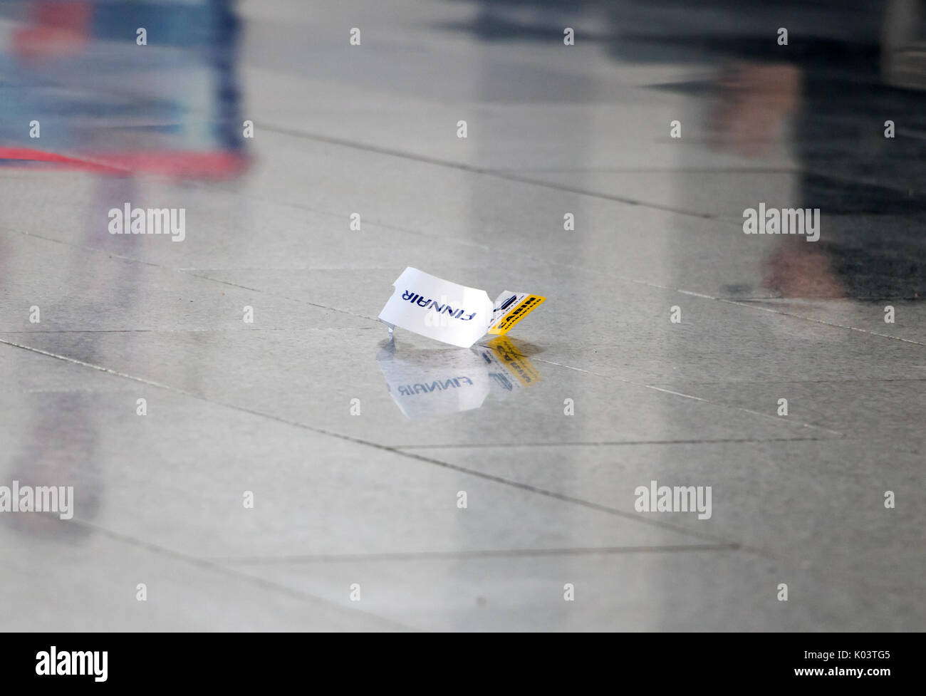 Biglietto bagagli giace sul pavimento in un vuoto di lobby presso l'aeroporto. Foto Stock