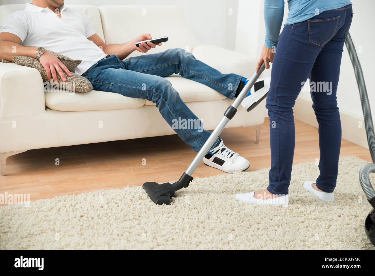 Uomo Che Solleva Il Divano Durante La Pulizia Del Pavimento Con  Aspirapolvere - Fotografie stock e altre immagini di Accudire - iStock